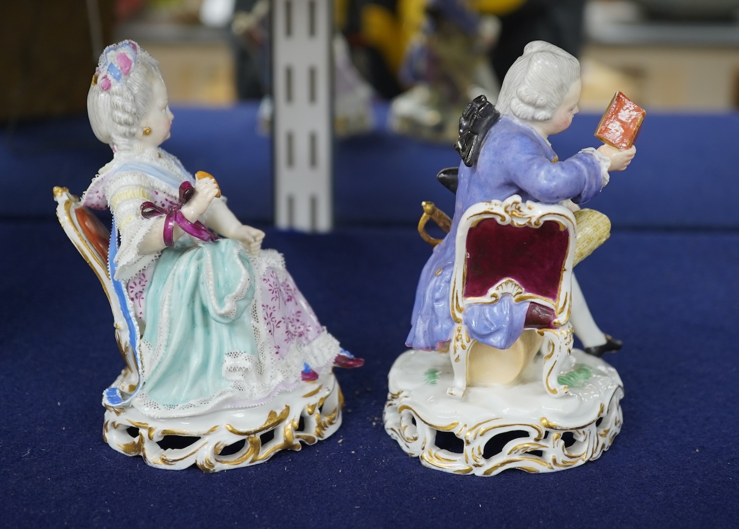A pair of 19th century Meissen figures of a girl holding a shell and a boy holding a book, in size model number 628, tallest 13cm